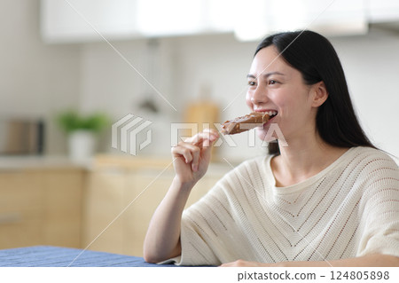 Asian woman biting a chocolate ice cream 124805898