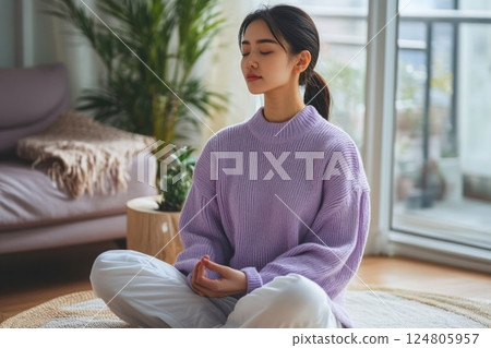 Woman meditating in the living room. Woman meditating in the living room. 124805957