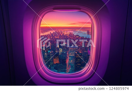 airplane window with the view of a cityscape at sunset. 124805974