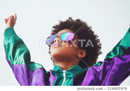 Young Black boy wearing oversized purple and green windbreaker jacket. 124805976