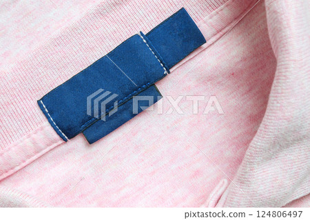 Blank blue laundry care clothes label on pink shirt fabric texture background Blank blue laundry care clothes label on pink shirt fabric texture background 124806497