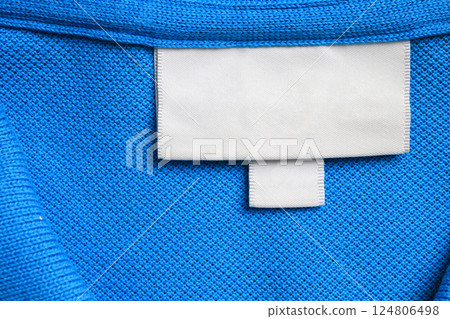 Blank white laundry care clothes label on blue shirt fabric texture background Blank white laundry care clothes label on blue shirt fabric texture background 124806498