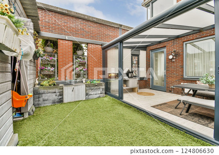 A contemporary outdoor patio featuring a modern design, stylish furniture, and lush greenery, ideal for relaxation and gatherings. 124806630