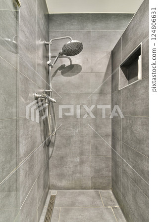 A sleek and contemporary shower featuring elegant gray tiles, showcasing a minimalist design that enhances any bathroom aesthetic. 124806631