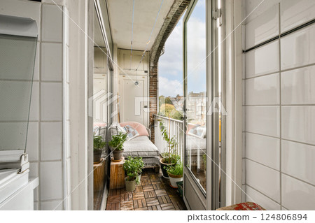 A charming balcony space adorned with greenery and comfortable seating, offering a peaceful retreat amidst urban surroundings. 124806894