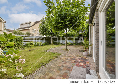 An inviting garden scene showcasing vibrant green trees and manicured landscapes with colorful stone pathways, enhancing outdoor aesthetics and tranquility. 124807126