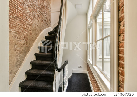 A beautifully designed staircase with a combination of modern and traditional elements, highlighted by exposed brick walls and elegant railings. A beautifully designed staircase with a combination of modern and traditional elements, highlighted by exposed brick walls and elegant railings. 124807320