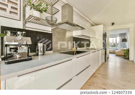 A sleek and modern kitchen featuring minimalist design elements, stainless steel appliances, and a warm wooden floor that enhances the contemporary atmosphere. A sleek and modern kitchen featuring minimalist design elements, stainless steel appliances, and a warm wooden floor that enhances the contemporary atmosphere. 124807339