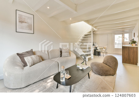 A stylish modern living room showcasing minimalist furniture and an open layout, emphasizing light and space with a neutral color palette. A stylish modern living room showcasing minimalist furniture and an open layout, emphasizing light and space with a neutral color palette. 124807603