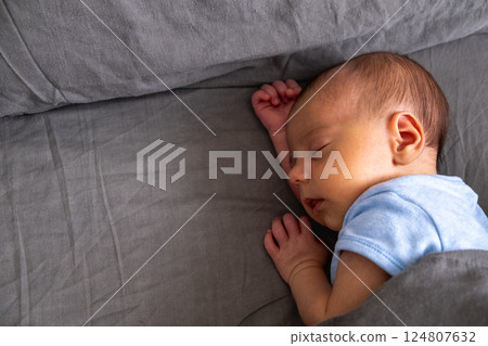 Newborn Baby Sleeping Peacefully on Bed 124807632