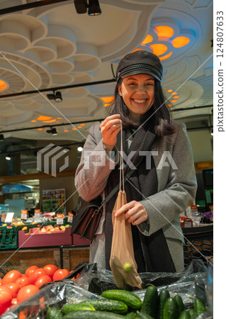 Woman Shopping for Cucumbers with Reusable Bag Woman Shopping for Cucumbers with Reusable Bag 124807633