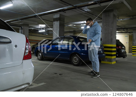 Person in Underground Parking Garage Figure Out of Stolen Car 124807646