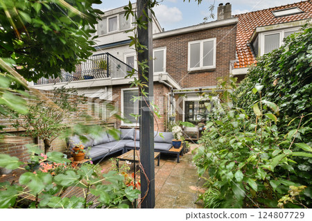 A serene backyard space featuring comfortable seating, surrounded by rich green plants, creating a perfect retreat for relaxation and gatherings. 124807729