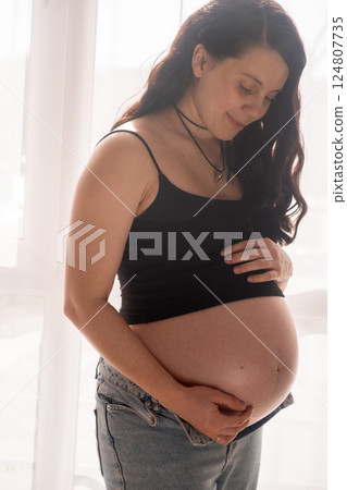 Intimate Moment of Expecting Parents by the Window 124807735