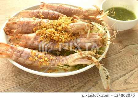 fried mantis shrimp with chop crispy garlic on plate dipping Thai spicy seafood sauce fried mantis shrimp with chop crispy garlic on plate dipping Thai spicy seafood sauce 124808070