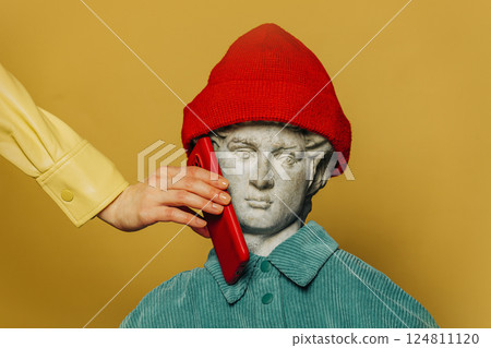 Antique statue of a young man in a red hipster hat and turquoise shirt 124811120