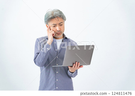 Full body photo of a senior man thinking with a laptop 124811476