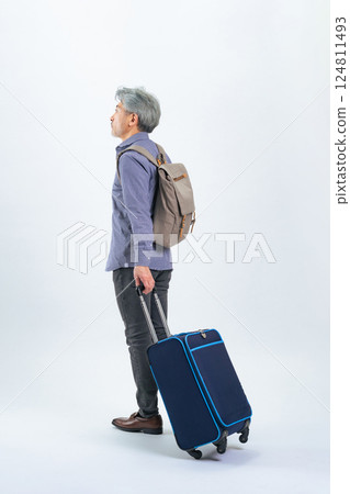 Full-body photo of a senior man walking with a carry bag 124811493