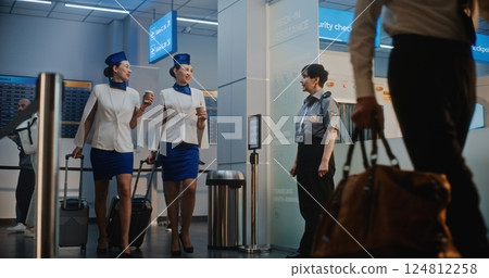 Crowded Airport Terminal: Airline Captain and Two Stewardesses Passing Security Checkpoint Crowded Airport Terminal: Airline Captain and Two Stewardesses Passing Security Checkpoint 124812258