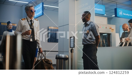 Flight Crew in Airport Terminal Walking with Luggage for Boarding Flight, Passing by Security Officer 124812259
