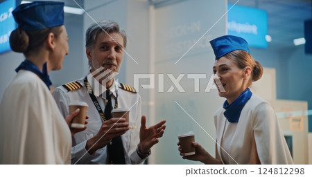 Airline Pilot Communicating with Two Flight Attendants in Crowded Airport Terminal Airline Pilot Communicating with Two Flight Attendants in Crowded Airport Terminal 124812298