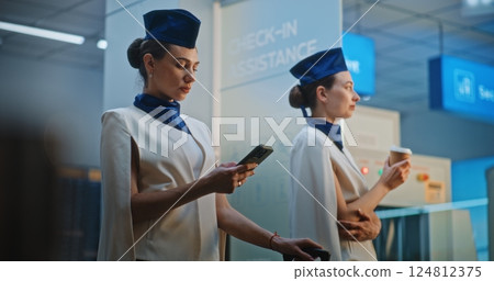 Two Beautiful Flight Attendants Talking, Waiting for Commercial Flight 124812375