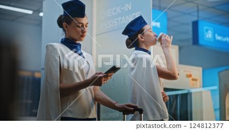 Two Beautiful Flight Attendants Talking, Waiting for Commercial Flight 124812377