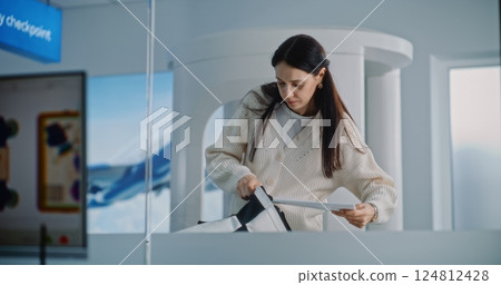 Woman with Carry-On Baggage During Screening. Computer Screen with X-ray Images of Luggage 124812428