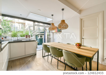 A sleek, modern kitchen featuring minimalistic design elements, natural light, and an inviting dining space with stylish seating. Perfect for contemporary living. A sleek, modern kitchen featuring minimalistic design elements, natural light, and an inviting dining space with stylish seating. Perfect for contemporary living. 124812433