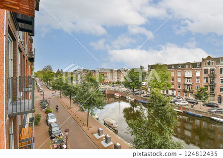 A vibrant city landscape showcasing a canal lined with trees and buildings under a partly cloudy sky, capturing urban life and nature's beauty in harmony. 124812435