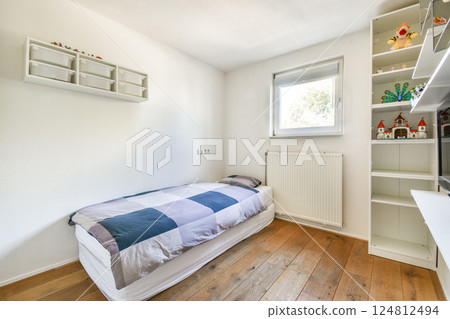 Features a simple, clean aesthetic with wooden flooring, a single bed, and natural light enhancing the serene atmosphere. 124812494