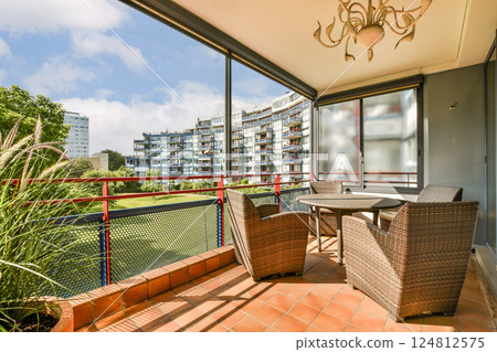 A stylish balcony featuring comfortable seating and an urban landscape. The design blends nature and contemporary living seamlessly. 124812575