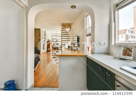 A spacious and modern open-concept kitchen leads into a stylish living area, highlighting sleek design and warm wooden accents. The light and airy atmosphere is inviting. A spacious and modern open-concept kitchen leads into a stylish living area, highlighting sleek design and warm wooden accents. The light and airy atmosphere is inviting. 124812595