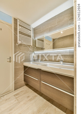 A stylish modern bathroom featuring sleek cabinetry, elegant fixtures, and ambient lighting, showcasing contemporary design trends for interiors. 124812604