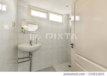 A clean and minimalistic bathroom showcasing white tiled walls, a round mirror, and a small sink, perfect for a compact space. A clean and minimalistic bathroom showcasing white tiled walls, a round mirror, and a small sink, perfect for a compact space. 124812641