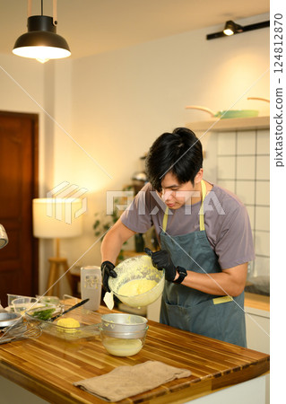 Man pouring freshly churned butter into strainer to separate buttermilk in a home kitchen Man pouring freshly churned butter into strainer to separate buttermilk in a home kitchen 124812870