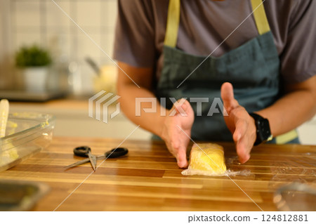 Close up of man shaping fresh homemade butter on tray in a modern kitchen Close up of man shaping fresh homemade butter on tray in a modern kitchen 124812881