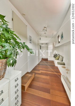 A spacious and minimalist interior featuring wooden flooring, green plants, and a sleek modern aesthetic. Perfect for contemporary living environments. A spacious and minimalist interior featuring wooden flooring, green plants, and a sleek modern aesthetic. Perfect for contemporary living environments. 124812882