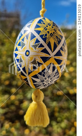 Easter eggs hanging brightly, showcasing traditional Ukrainian pysanka in national colors yellow and blue with intricate folk patterns 124813019
