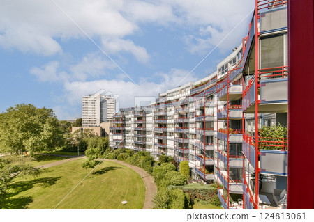 A vibrant view of contemporary residential buildings surrounded by greenery and blue skies, showcasing urban living harmoniously integrated with nature. A vibrant view of contemporary residential buildings surrounded by greenery and blue skies, showcasing urban living harmoniously integrated with nature. 124813061