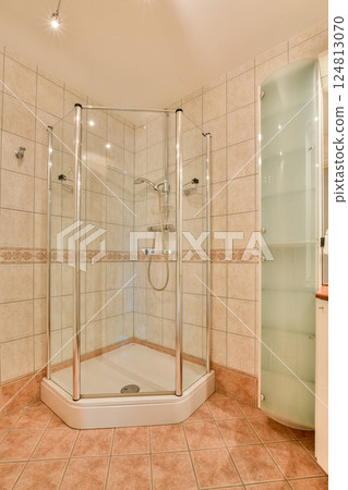 A sleek and modern shower stall featuring glass panels and elegant tile work. The spacious layout highlights contemporary bathroom aesthetics. 124813070
