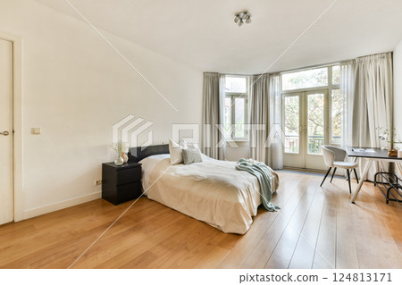 A spacious and minimalist bedroom featuring a large window, wooden flooring, and a simple bed, creating a serene and inviting atmosphere. A spacious and minimalist bedroom featuring a large window, wooden flooring, and a simple bed, creating a serene and inviting atmosphere. 124813171