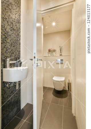 A sleek and contemporary bathroom showcasing elegant fixtures and a stylish tiled wall, creating a sophisticated ambiance. A sleek and contemporary bathroom showcasing elegant fixtures and a stylish tiled wall, creating a sophisticated ambiance. 124813177