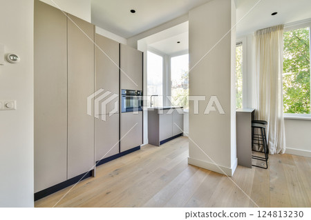 A contemporary kitchen featuring sleek cabinets, large windows, and natural light, designed for functionality and aesthetics in a minimalist style. A contemporary kitchen featuring sleek cabinets, large windows, and natural light, designed for functionality and aesthetics in a minimalist style. 124813230