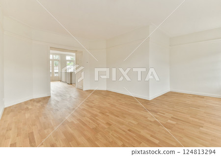 A bright and airy interior space showcasing a wooden floor and large windows, perfect for a contemporary home or office setup. 124813294