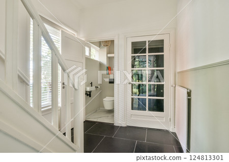 A bright and airy entrance hall featuring sleek lines, contemporary decor, and natural light streaming through the windows, creating a welcoming atmosphere. 124813301