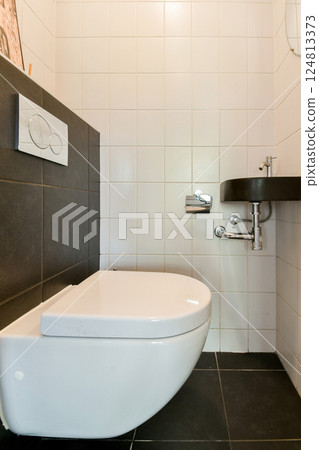 A sleek and modern bathroom showcasing a minimalistic toilet installation and contemporary wall design with clean lines and subdued colors. A sleek and modern bathroom showcasing a minimalistic toilet installation and contemporary wall design with clean lines and subdued colors. 124813373