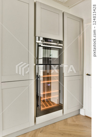 Sleek modern kitchen design featuring a built-in refrigerator with a streamlined appearance and elegant cabinetry. 124813428