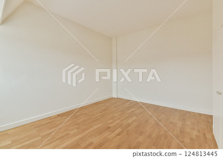 A spacious, minimalist room featuring bare walls and smooth wooden flooring, perfect for various design ideas and interior setups. 124813445