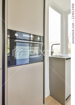A sleek modern kitchen featuring minimalistic cabinets and an open window allowing natural light to illuminate the space. A sleek modern kitchen featuring minimalistic cabinets and an open window allowing natural light to illuminate the space. 124813498